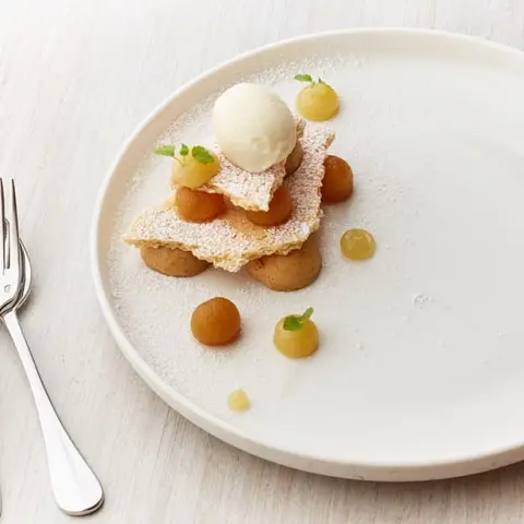 A bakery display case, a plate of choux pastries and a plated dessert (3)